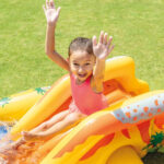 Bambina su scivolo gonfiabile in giardino