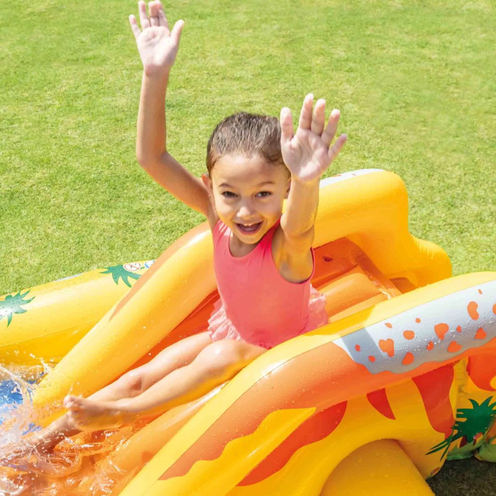 Bambina su scivolo gonfiabile in giardino