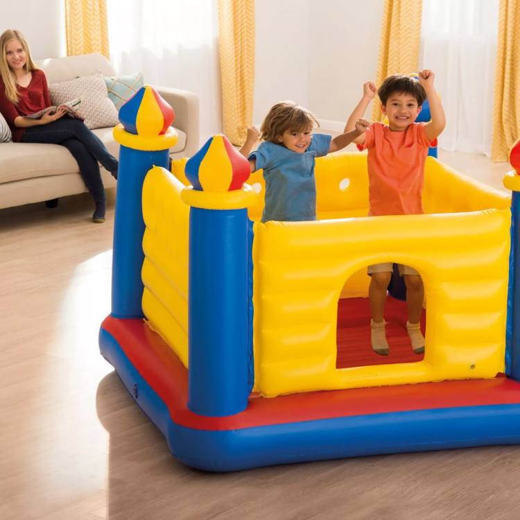 Bambini giocano su castello gonfiabile in soggiorno