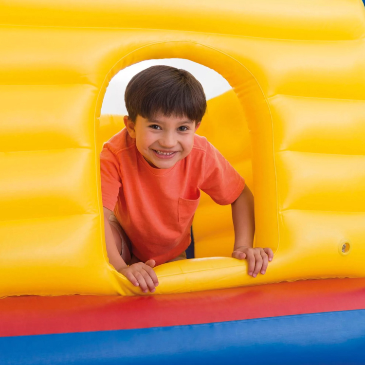 Bambino sorridente affacciato da un gonfiabile giallo