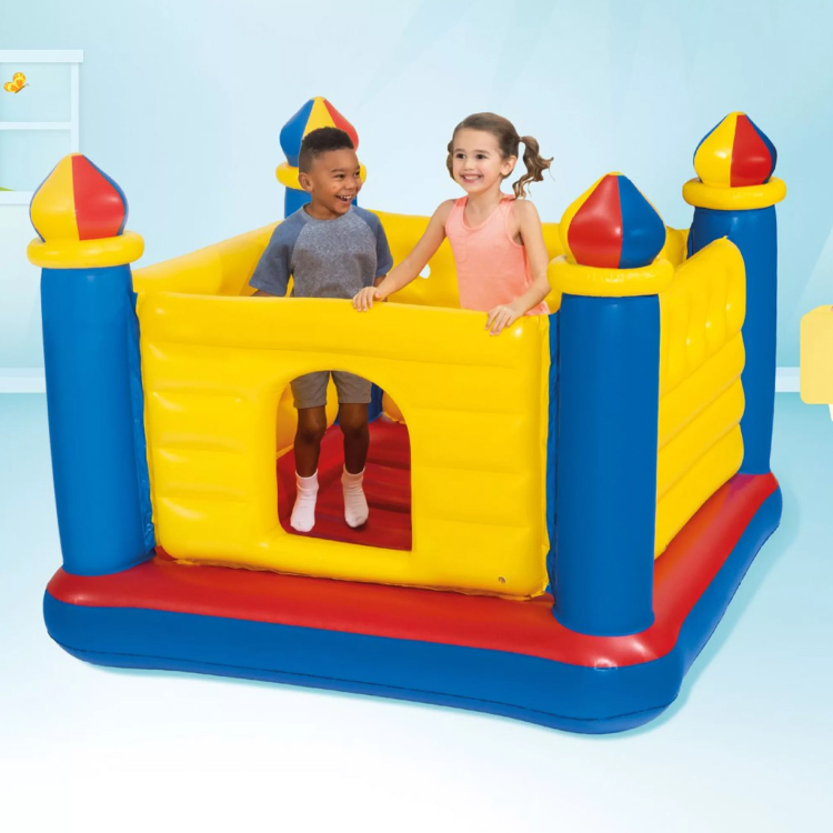 Due bambini giocano in un castello gonfiabile colorato
