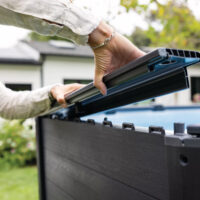 Persona installa pannello superiore su recinzione da giardino