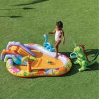 Bambina gioca in piscina gonfiabile con dinosauri