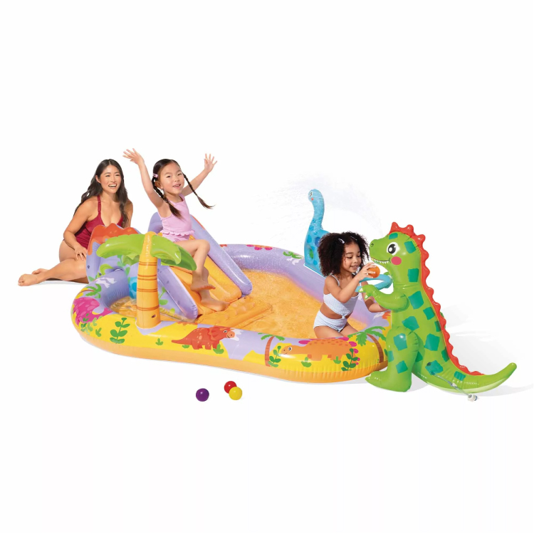 Bambini giocano in piscina gonfiabile con dinosauro